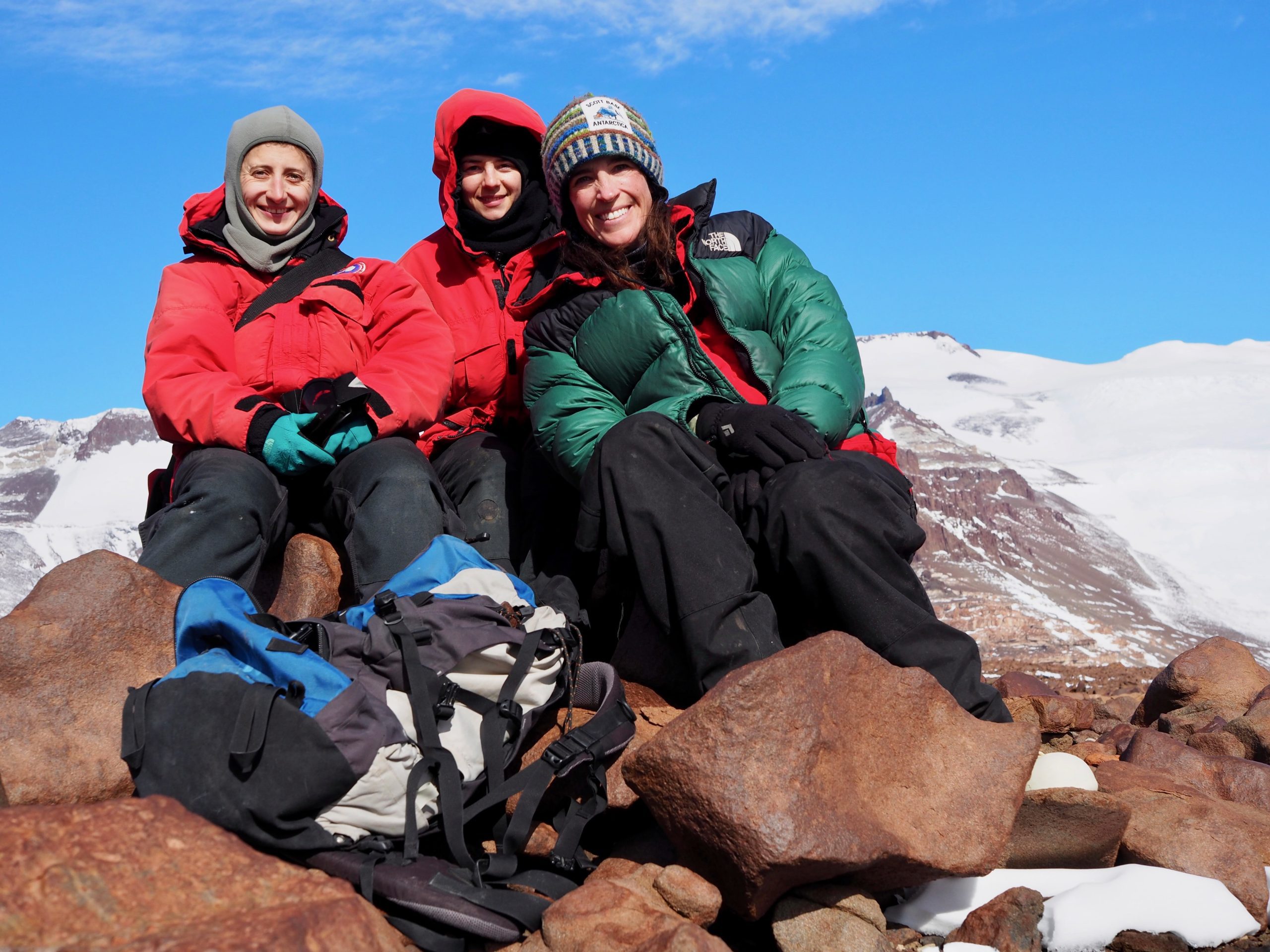 Team members sitting on a rock