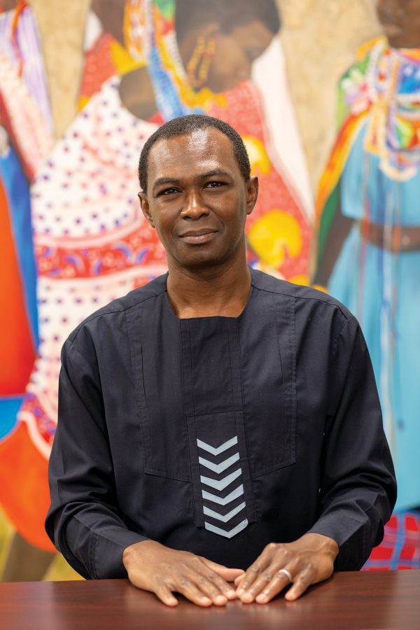 Akin Ogundiran in front of vivid painting