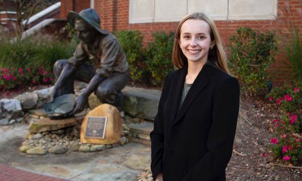 Megan Bird in front of prospector statue on campus