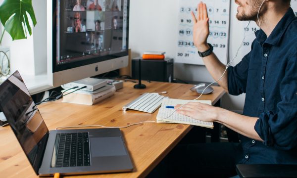 Man using computer with colleagues on screen