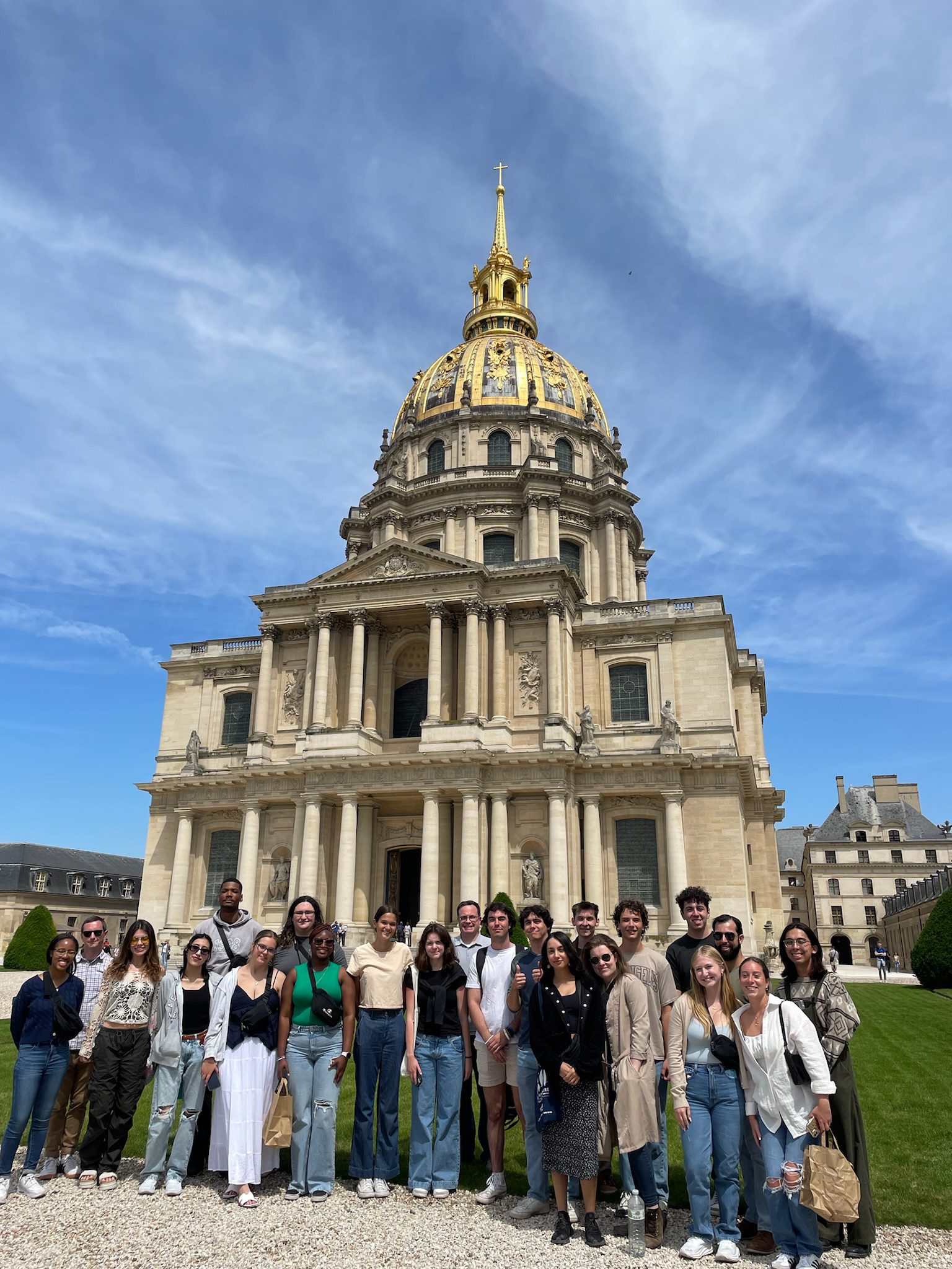 Students stand in front of an ornate building in France.