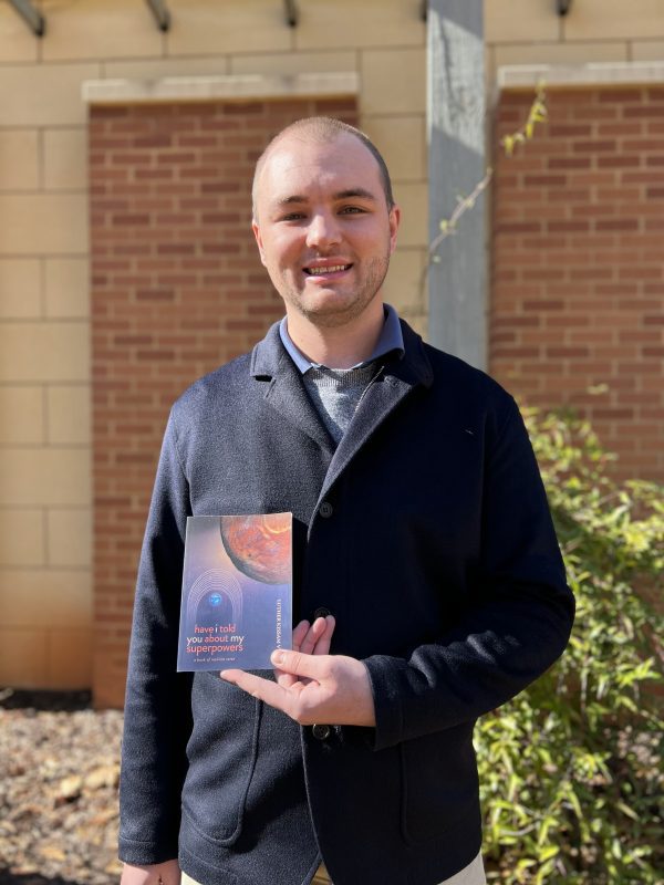 Luther Cole Kissam V holds his book of poetry.