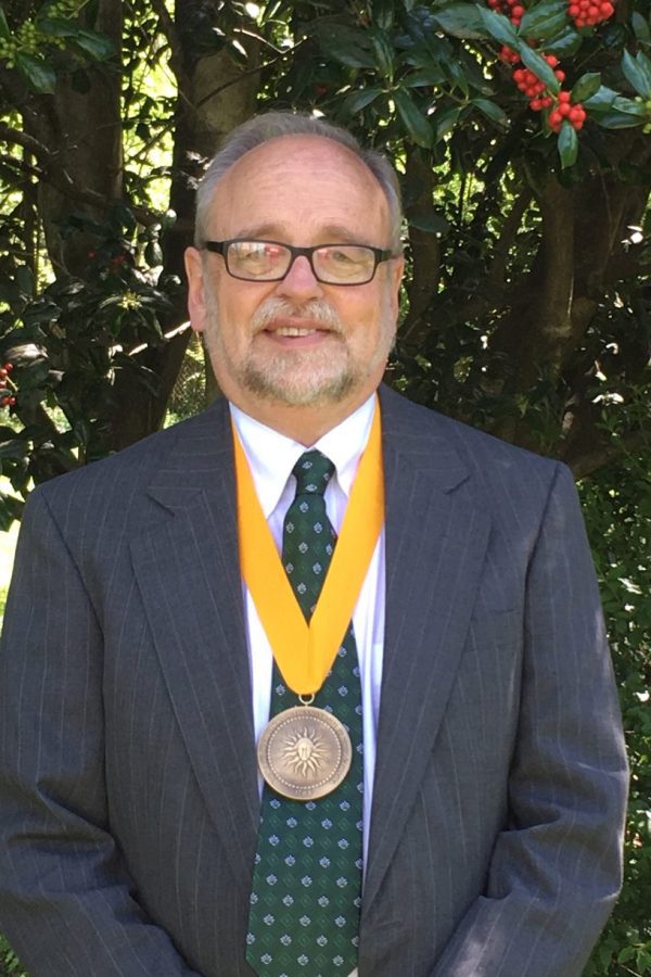 West wears a medal with a gold ribbon.