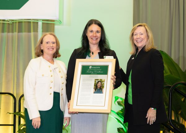 Jeanette Bennett holds her framed nomination standing between Provost Troyer and Chancellor Gaber.