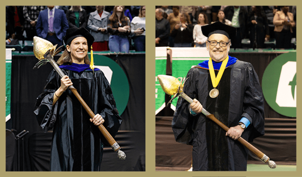 Margaret Quinlan and Mark West in graduation regalia, each holding the mace on stage at graduation.