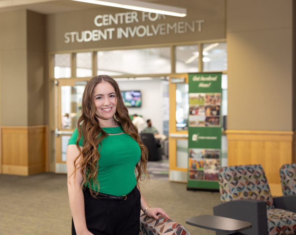 Grace Cooper in front of the Office of Student involvement in the Student Union.