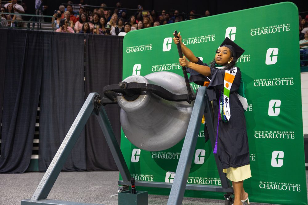 Pennda Arami rings the victory bell at UNC Charlotte commencement.
