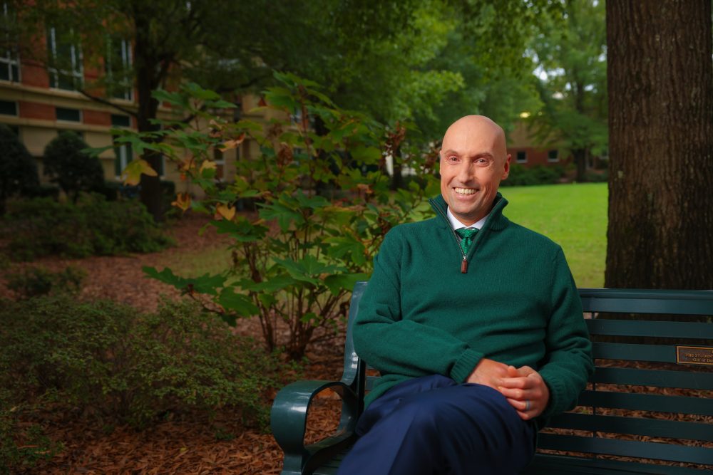 Chris Boyer, founding dean of CHESS, sits on a bench outside Fretwell.