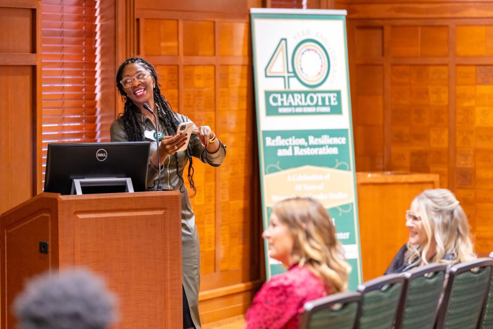 J. Joy Davis presents while reading notes from her phone at the WGST 40th anniversary celebration in 2024.
