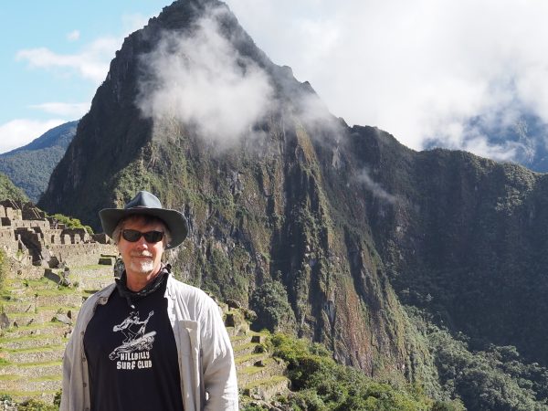 Professor Dennis Ogburn posing in front of Machu Picchu on a sunny day in Peru.