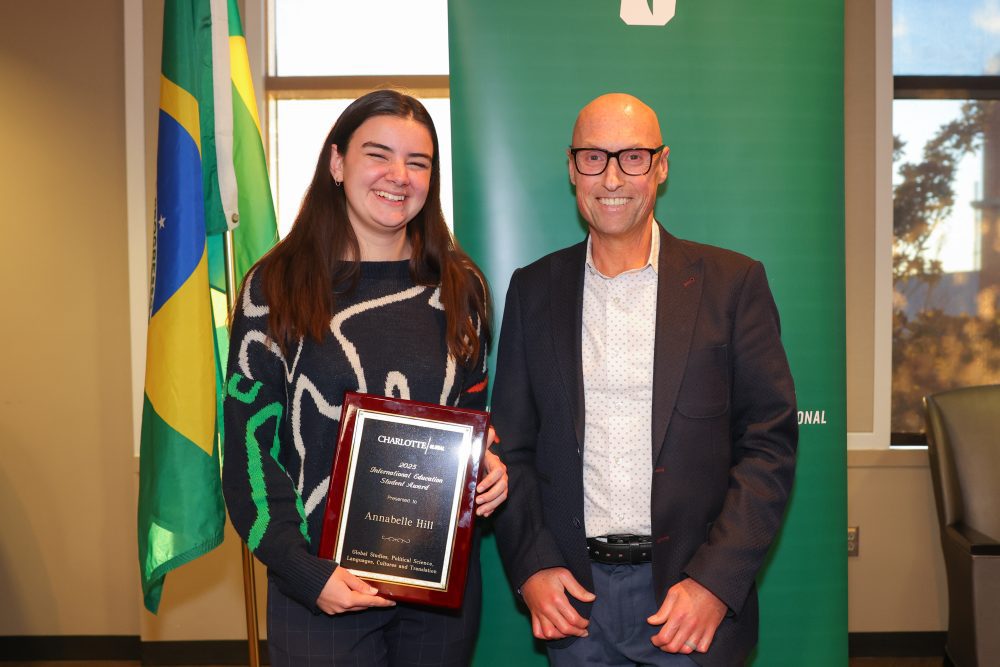 Hill holding her award plaque and posing with CHESS Dean Chris Boyer.