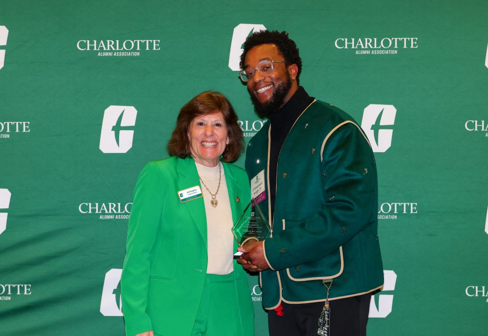 C. Emmanuel Wright poses with his award and Jodi Kaplan of the UNC Charlotte Alumni Association. 