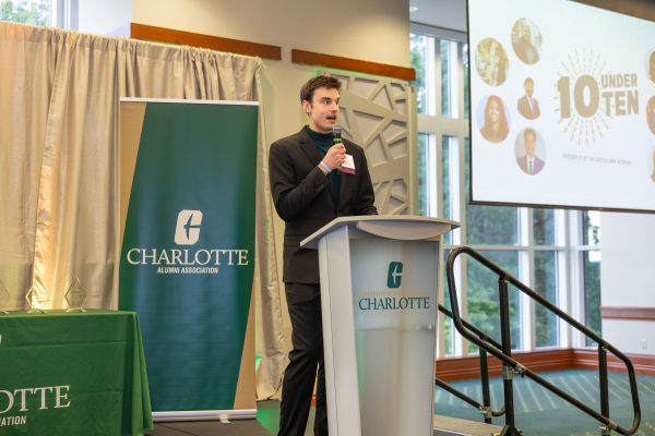 The emcee speaks on stage at the podium.