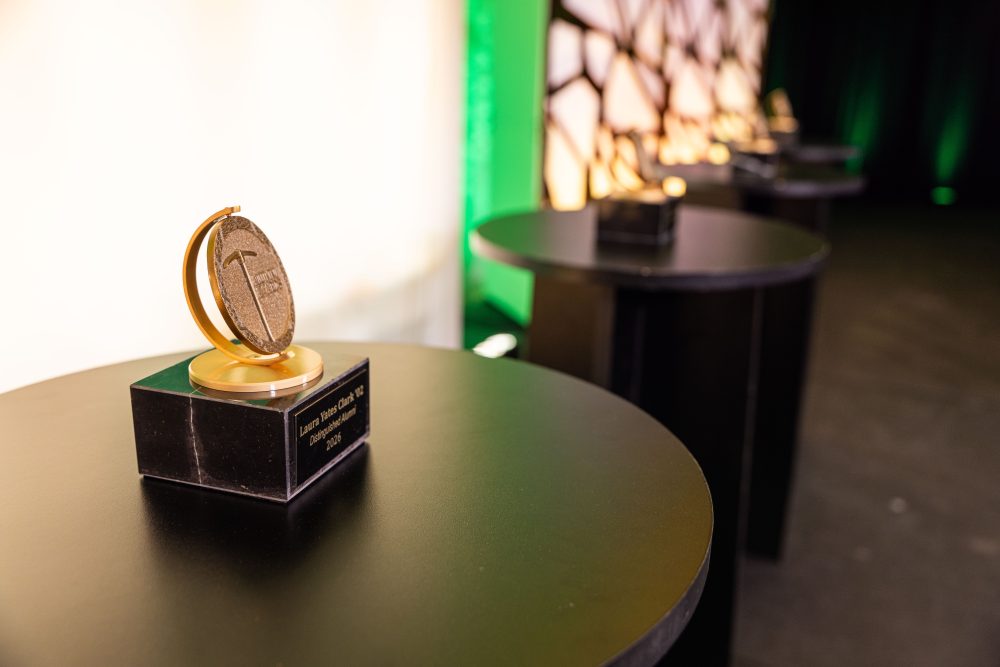 Laura Yates Clark's UNC Charlotte Distinguished Alumni award sits on a table, engraved with her name.