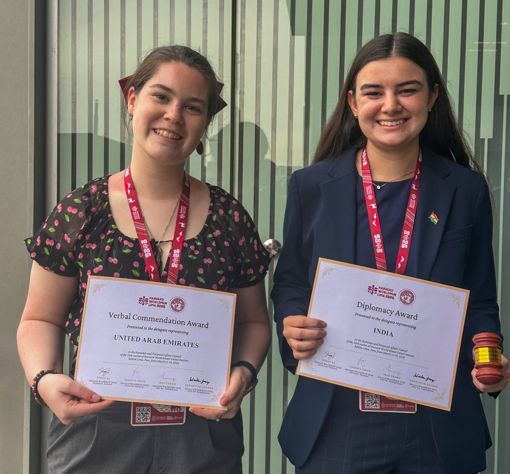 Emma Wical and Annabelle Hill hold their certificate awards from Harvard World Model United Nations.