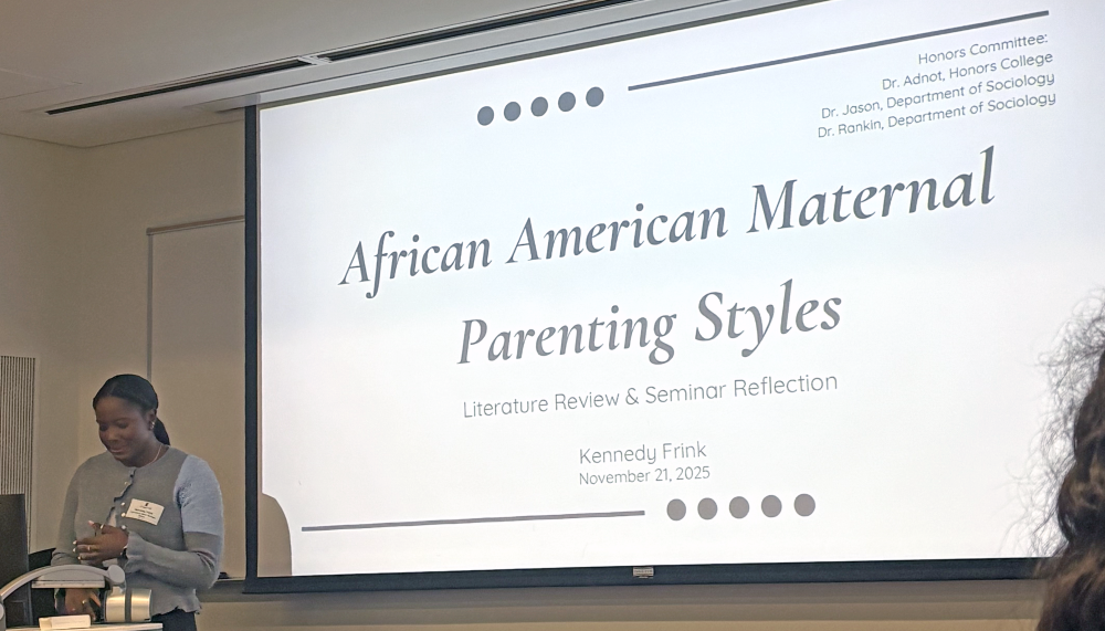 Frink presenting a powerpoint that reads "African American Maternal Parenting Styles: Literature Review & Seminar Reflection"