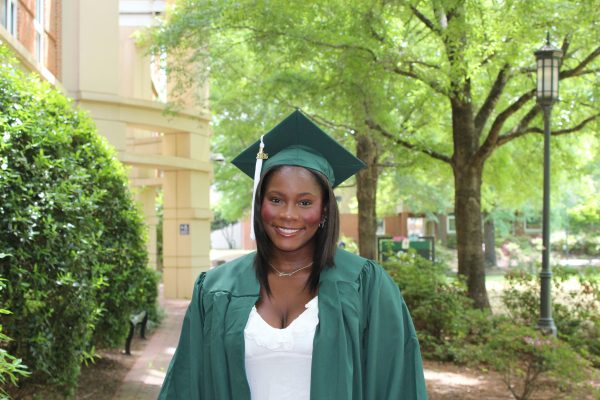 Kennedy Frink posing for a graduation photo outside at UNC Charlotte