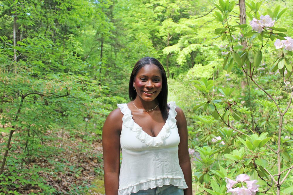Frink poses with trees and flowers in the background