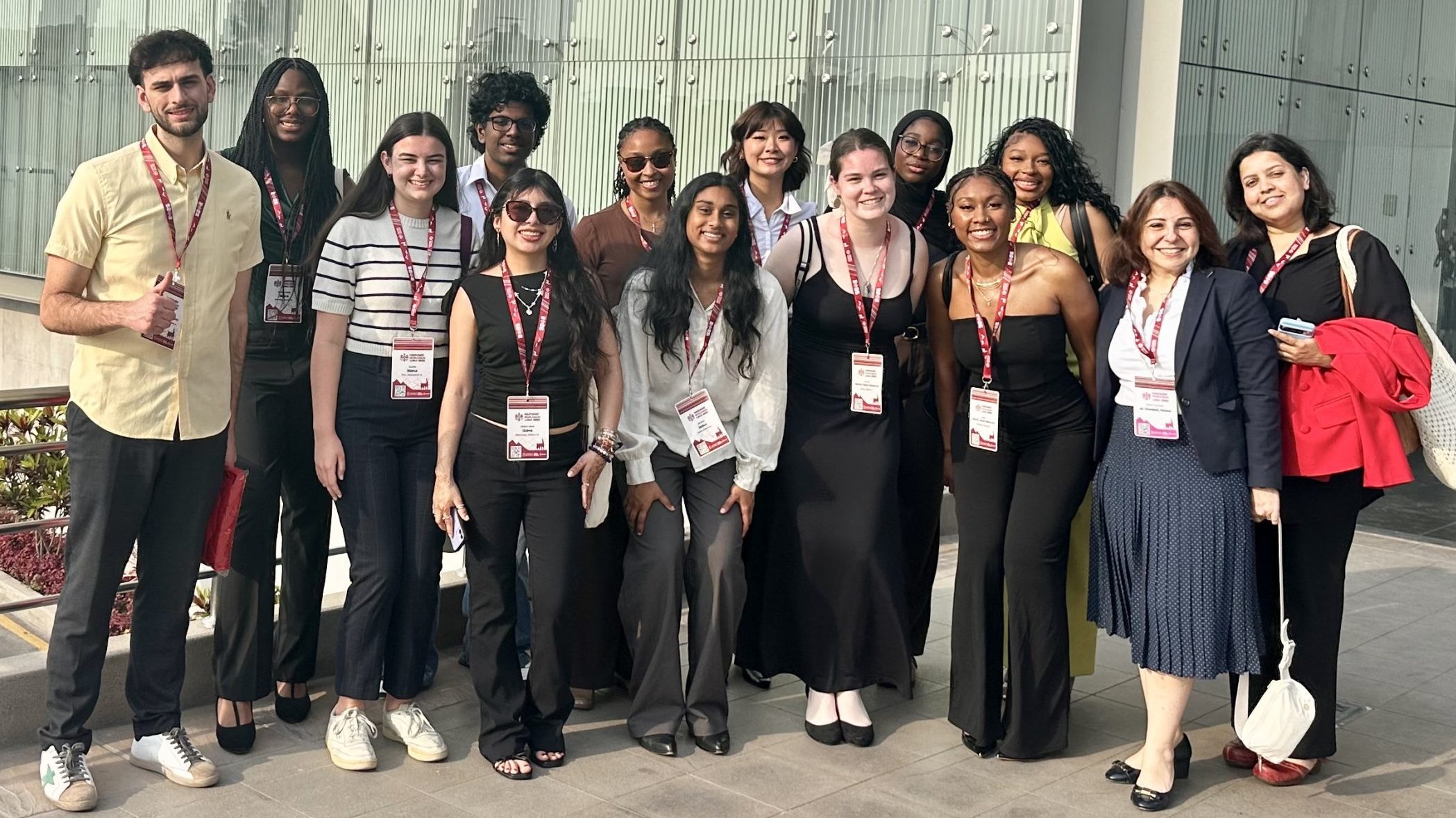 14 UNC Charlotte students and faculty wearing professional clothing smile at the 2026 Harvard World Model United Nations conference in Lima, Peru.