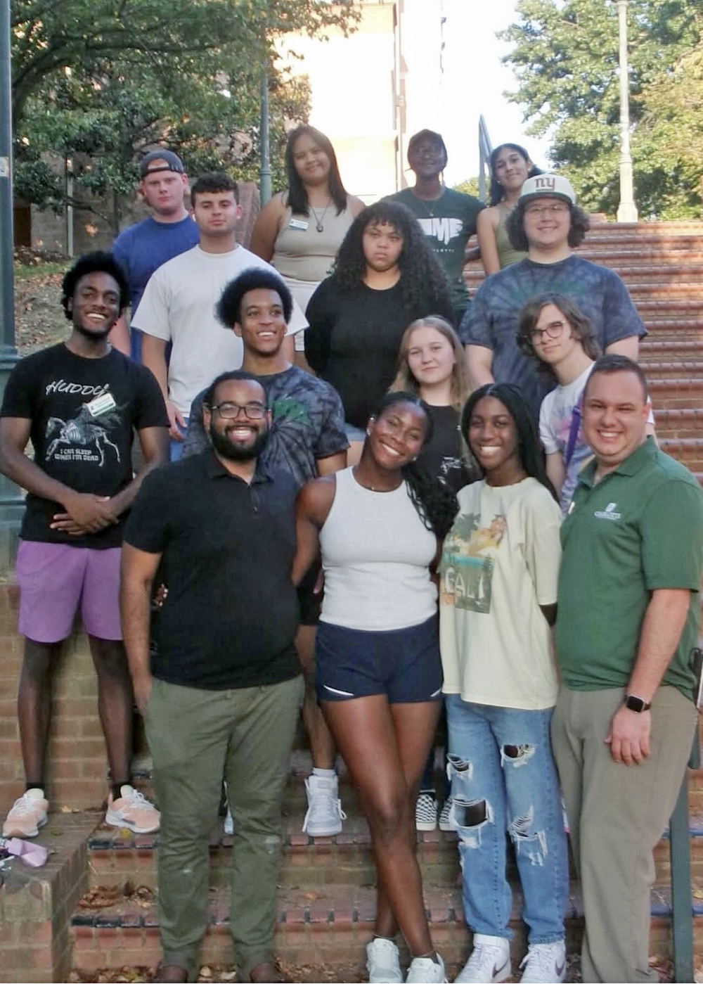 Frink and housing team members take a group photo on stairs.