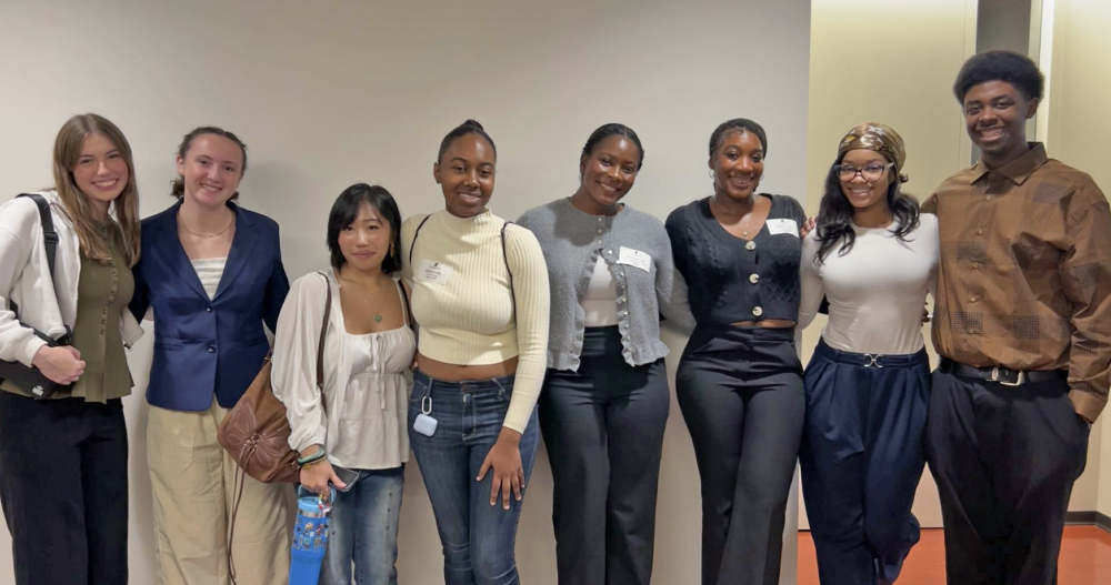 Frink taking a group photo with seven students