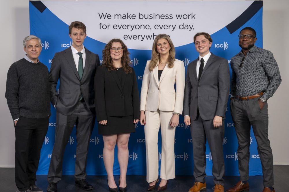 The mediation team (students and faculty) poses for a group shot in front of an ICC banner.