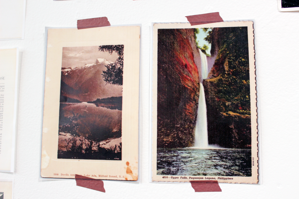 Vintage postcard taped to the wall featuring a tall waterfall dropping into a body of water.