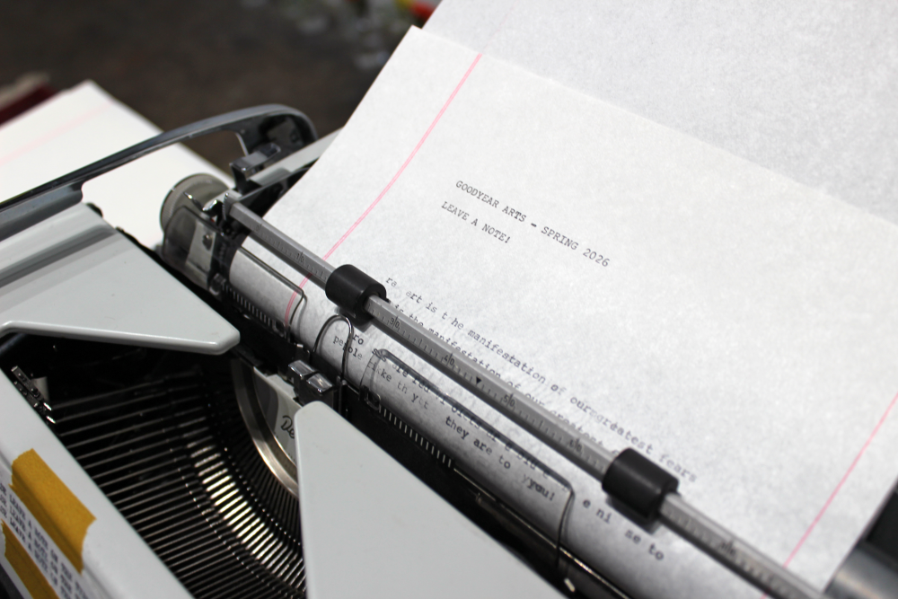 A close up image of the typewriter paper which reads, "Goodyear Arts - Spring 2026" and "Leave a note!"