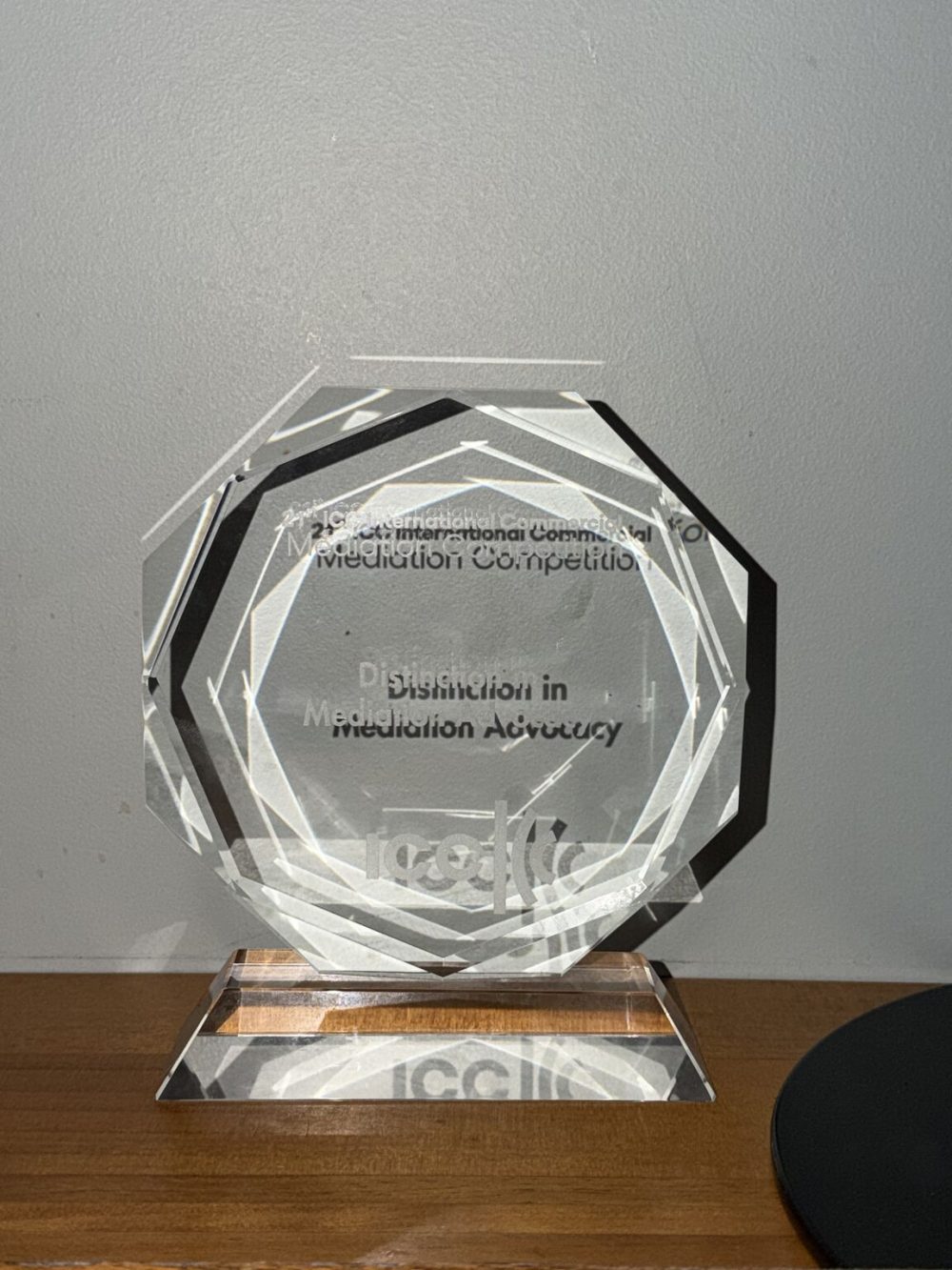 A close up of the "Distinction in Mediation Advocacy" glass award.