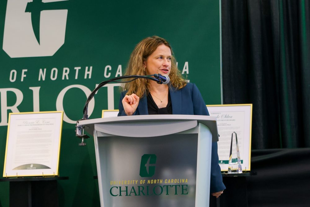 Marth Kropf speaks at the podium during the 2026 UNC Charlotte spring faculty award ceremony.