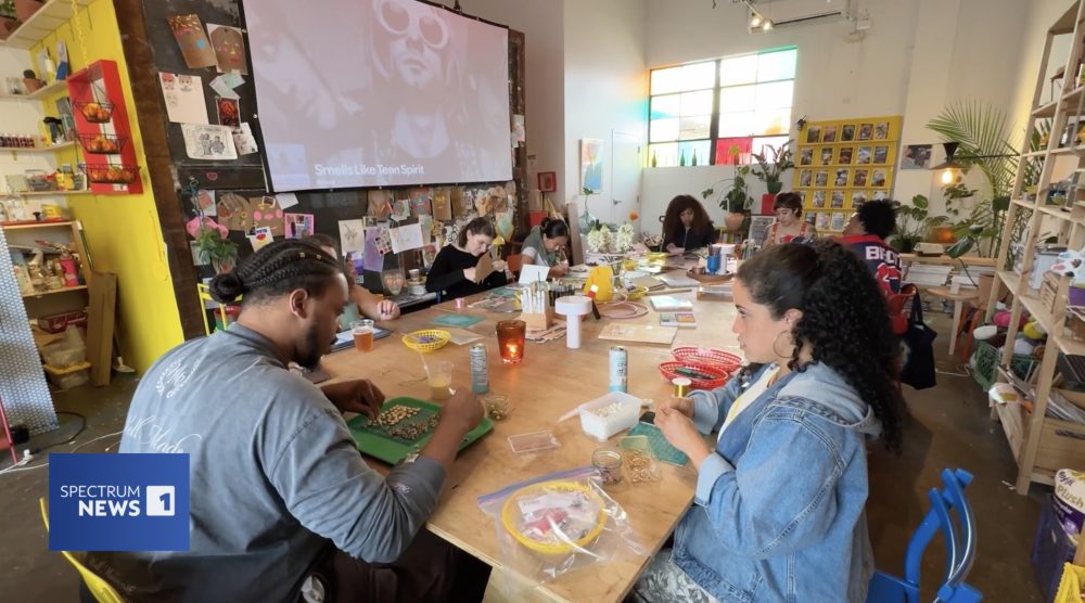 People crafting at a table inside of La Bodeguita.