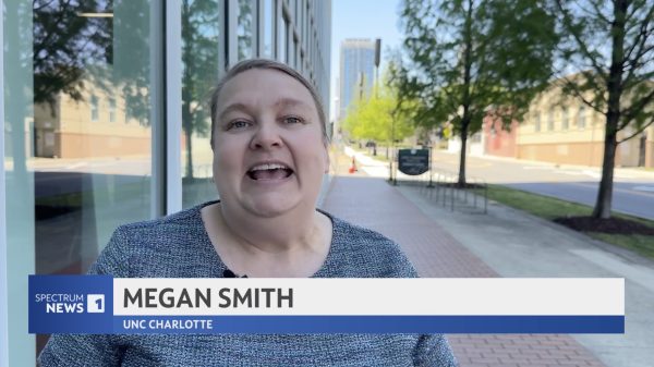 Megan Smith speaking to Spectrum News 1 about third spaces while standing on the sidewalk in front of the Dubois Building in Uptown.