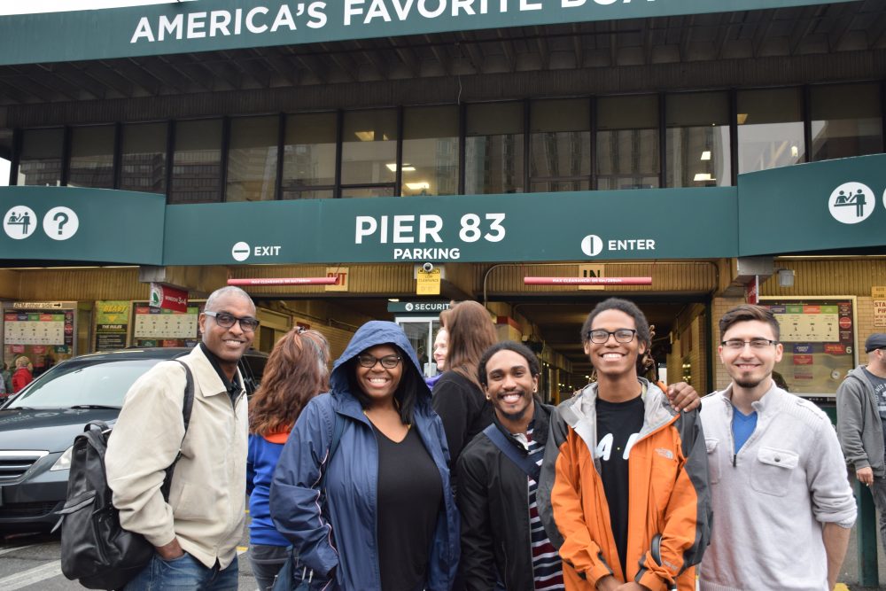Jeffrey Leak stands smiling with students at Pier 83 while attending a conference in New York.