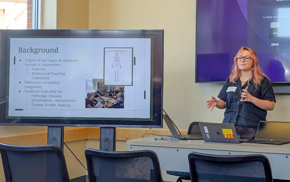 Mayah Clark, UNC Charlotte anthropology student in the College of Humanities & Earth and Social Sciences who conducted undergraduate and honors research, gives a presentation of her research to an audience during the UNC Charlotte Office of Undergraduate Research spring 2026 Research Symposium.