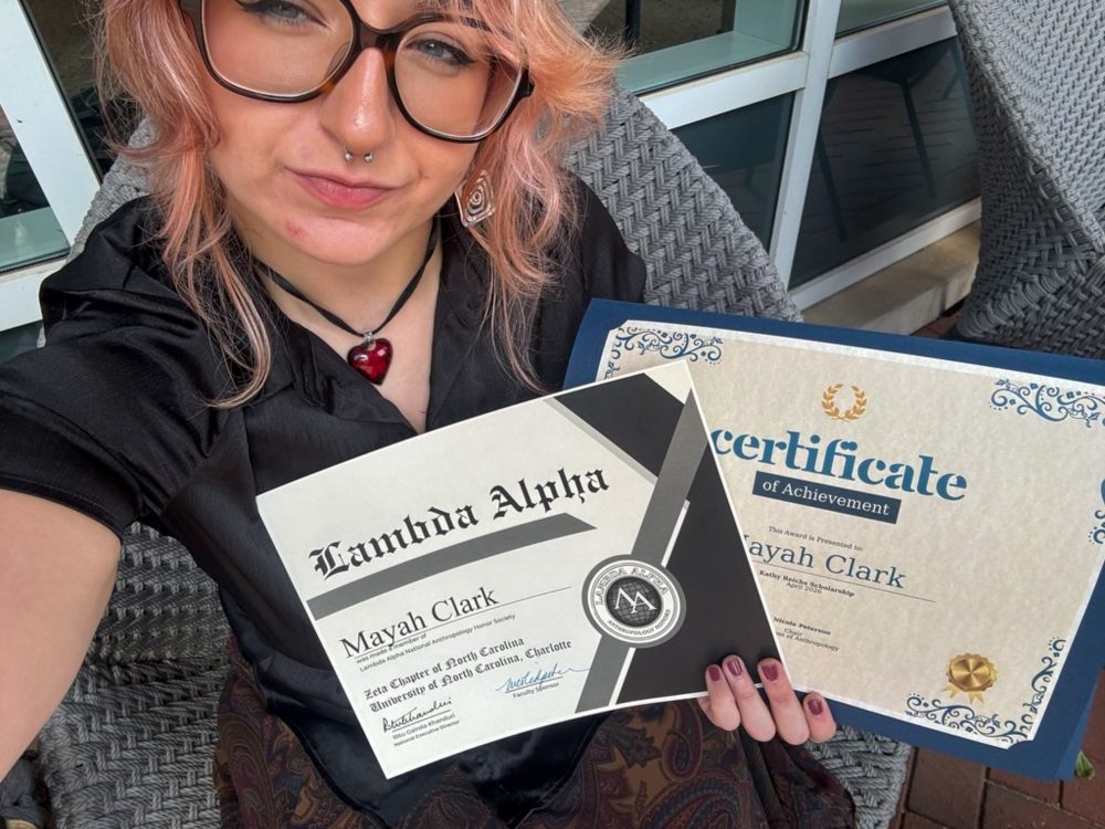 Mayah Clark, UNC Charlotte anthropology student in the College of Humanities & Earth and Social Sciences who conducted undergraduate and honors research, holds two certificates: the recipient of the Kathy Reichs Scholarship for April 2026 and as a member of the Zeta Chapter of Lambda Alpha at UNC Charlotte.
