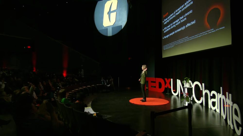 Alyssa McGonagle, professor of psychological and organizational science in the UNC Charlotte College of Humanities & Earth and Social Sciences, asks her TEDx talk audience to raise their hands if they or someone they know is living with a chronic health condition.